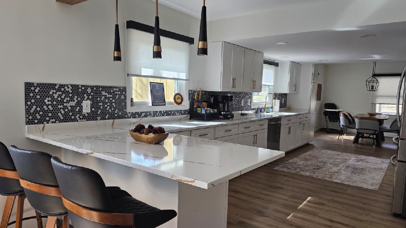 Chef's kitchen with long quartz countertops and peninsula island at Mojo Manor